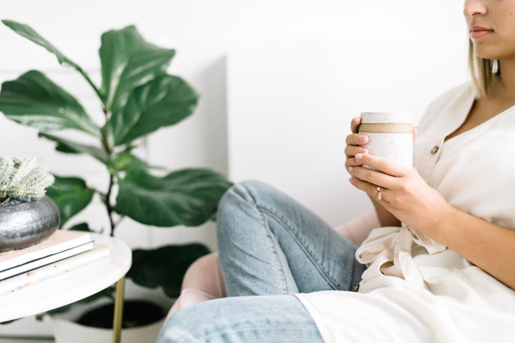 A woman sitting in a chair holding a mug