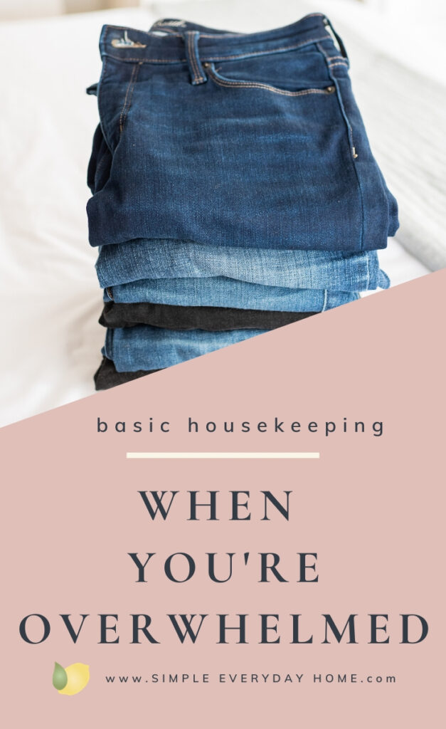 Blue jeans folded and stacked on a bed with the words "basic housekeeping, when you're overwhelmed"