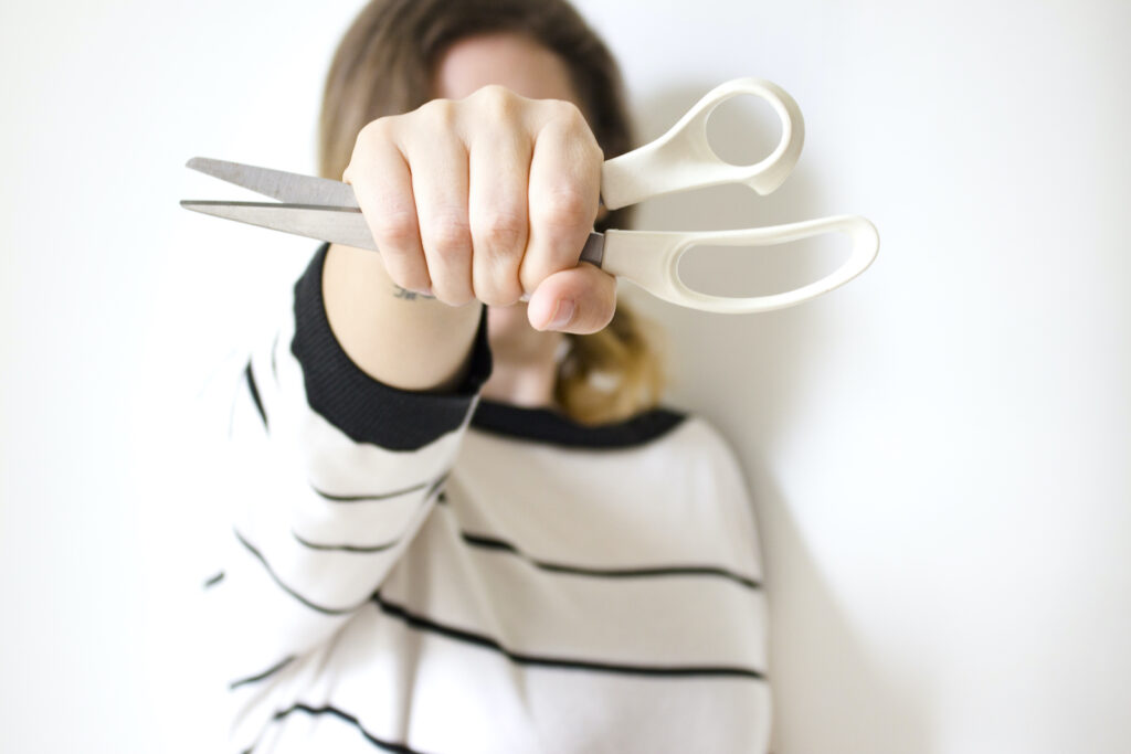 A woman holding up scissors