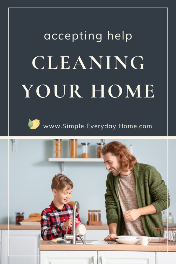 A dad smiling at his son washing dishes with the words "accepting help cleaning your home"