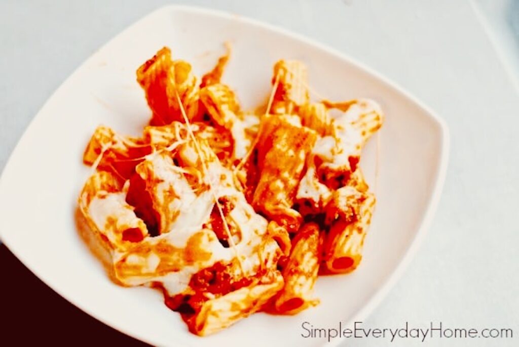 Finished rigatoni and melted cheese in bowl