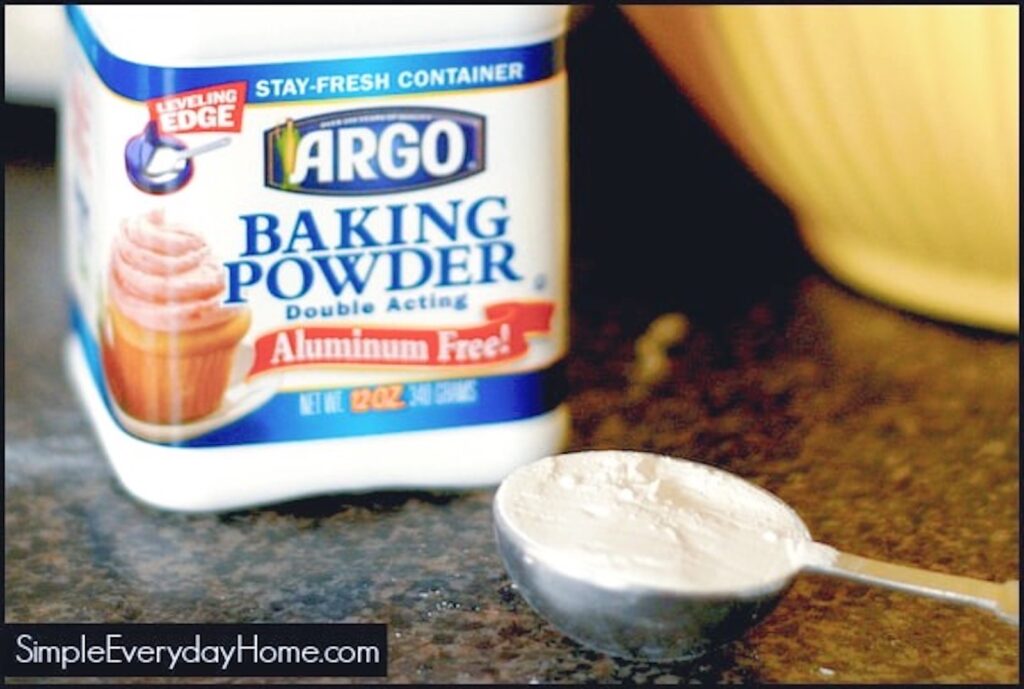 Measuring spoon of baking powder beside carton