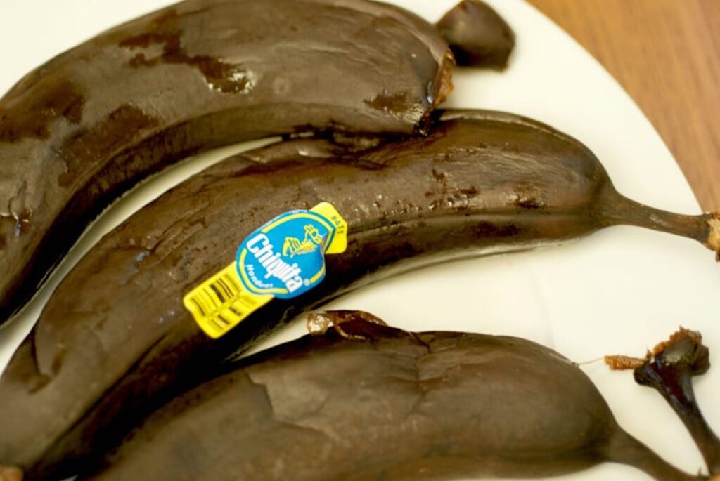 Dark brown bananas thawing on a plate