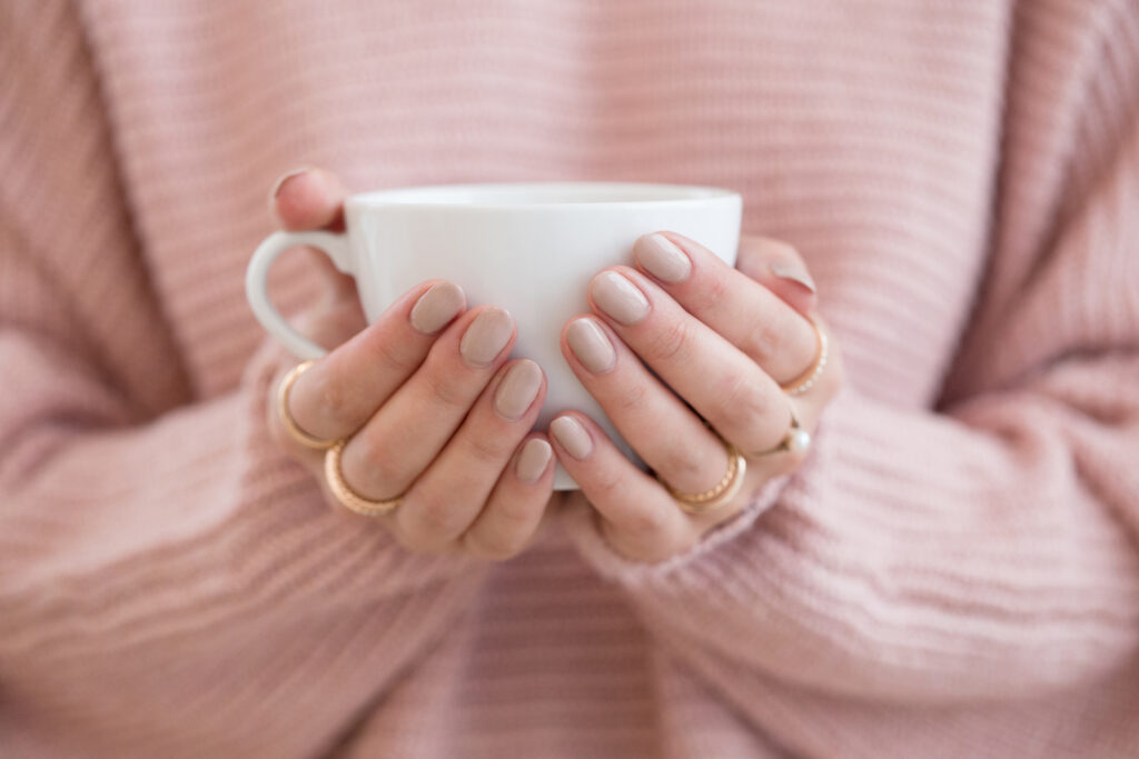 a woman's hands holding a tea cup