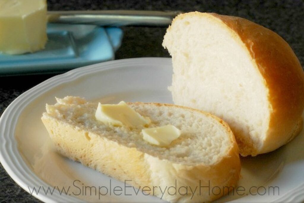 Sliced french bread on plate with butter