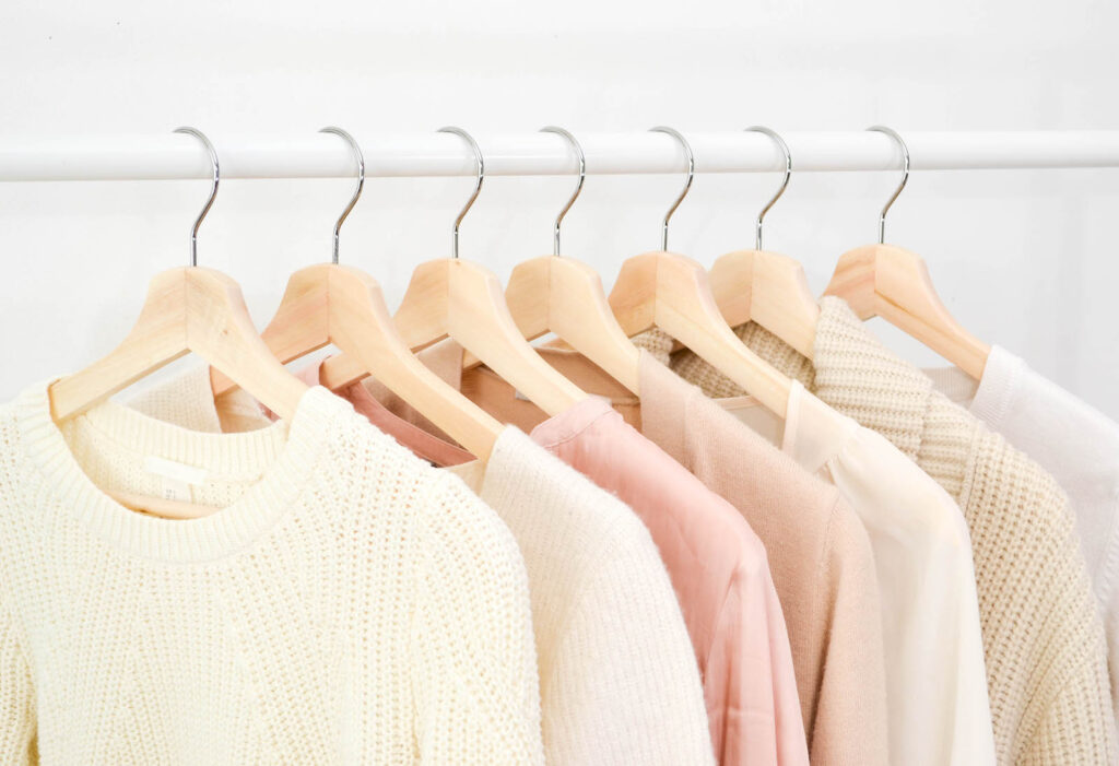 Pink and cream sweater hanging on a rack
