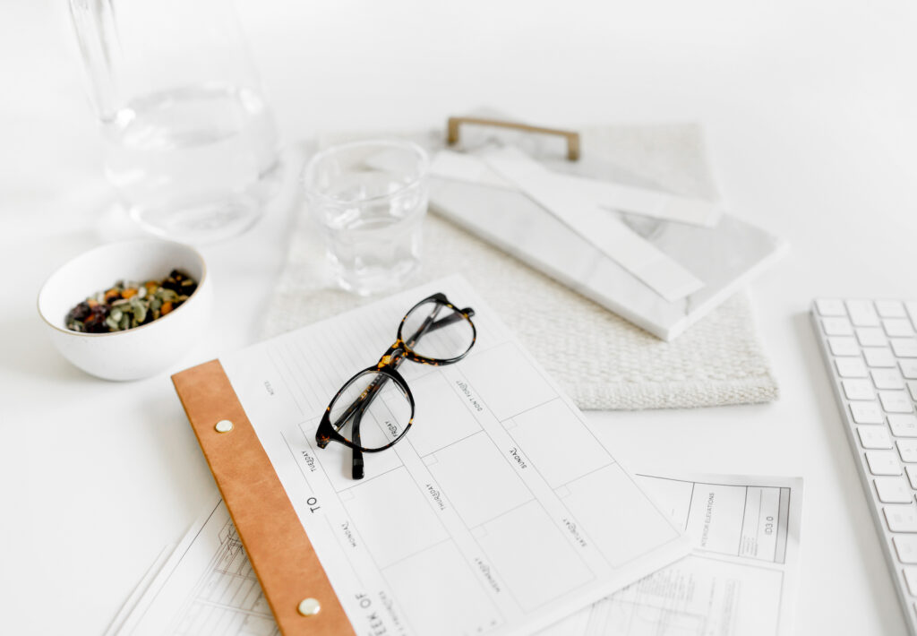 a desk with calendar and reading glasses