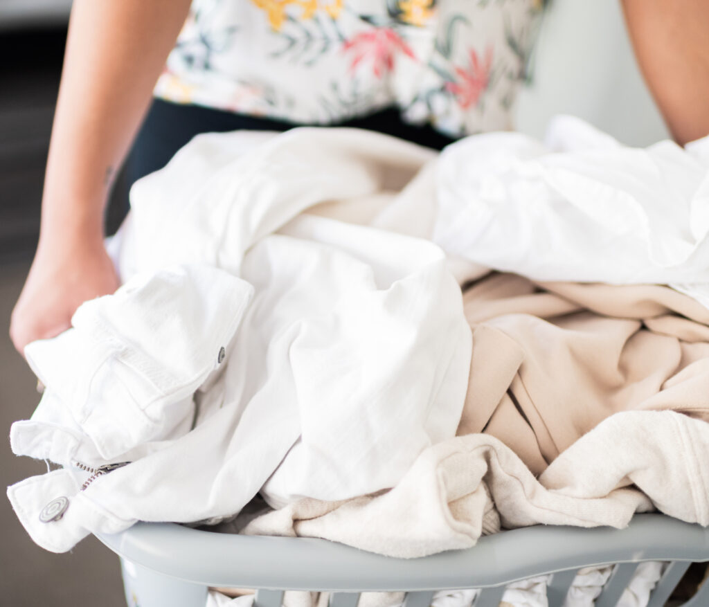 Woman holding a laundry basket overflowing with laundry