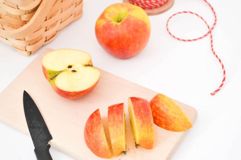 An apple being sliced on a cutting board