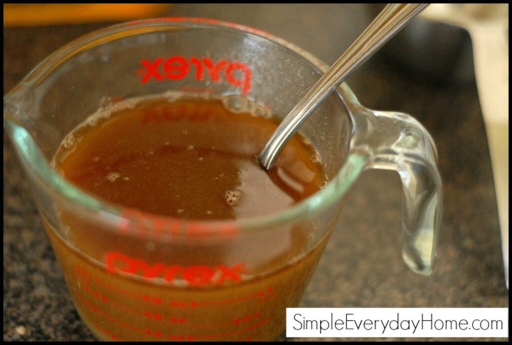 Brown sugar and juice being mixed in glass measuring cup