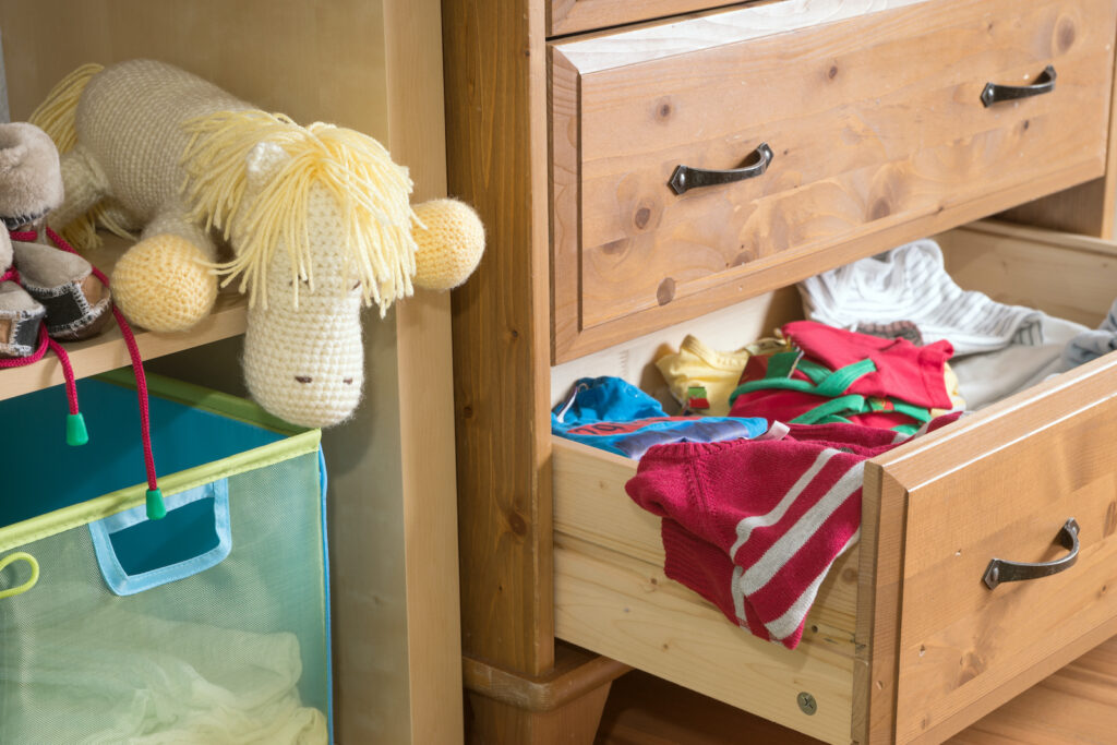 a child's room with clothes in a drawer