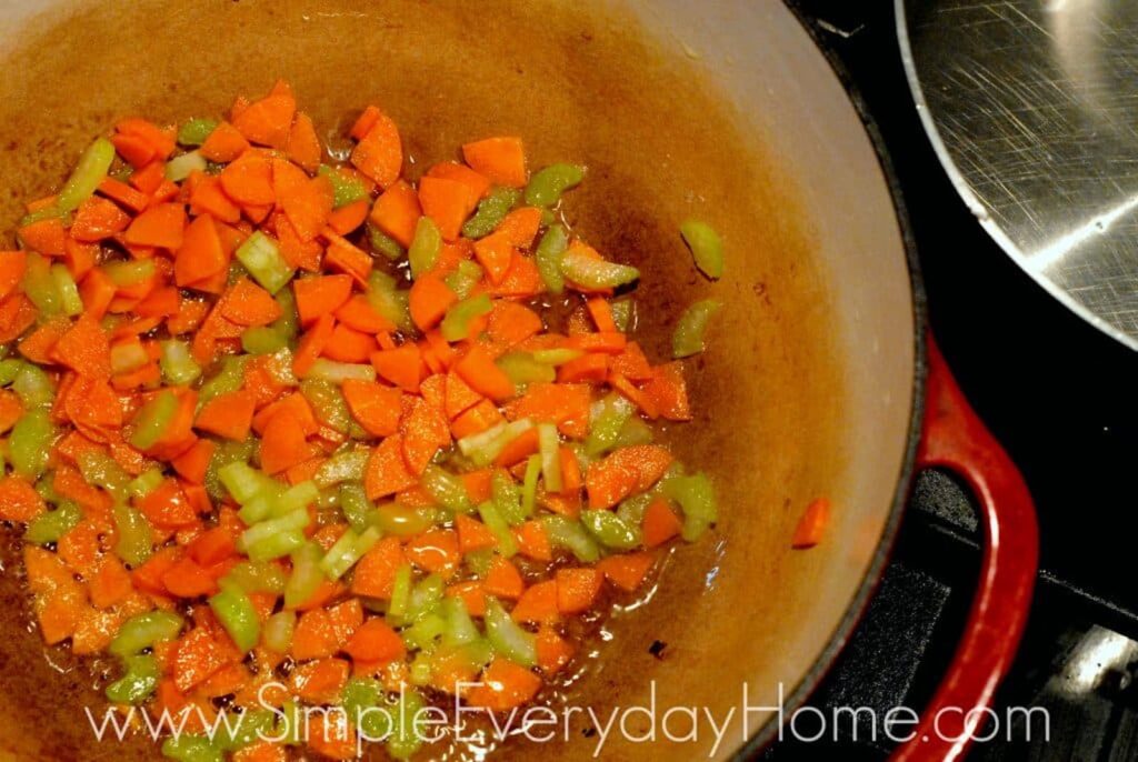 Diced carrots and celery cooking in Dutch oven