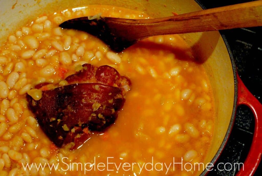 Soup being stirred with wooden spoon