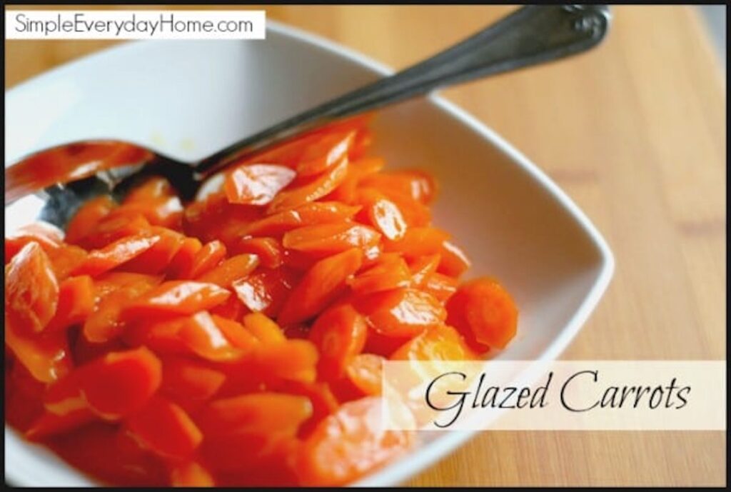 Glazed carrots in white dish with serving spoon