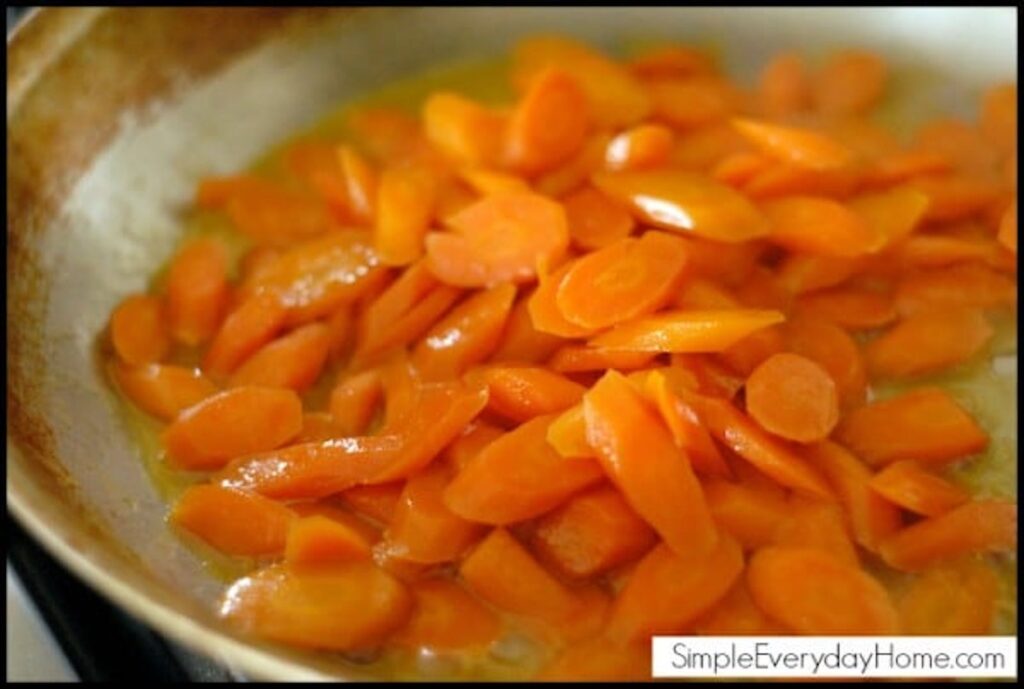 Carrots cooking in pan with glaze thickening