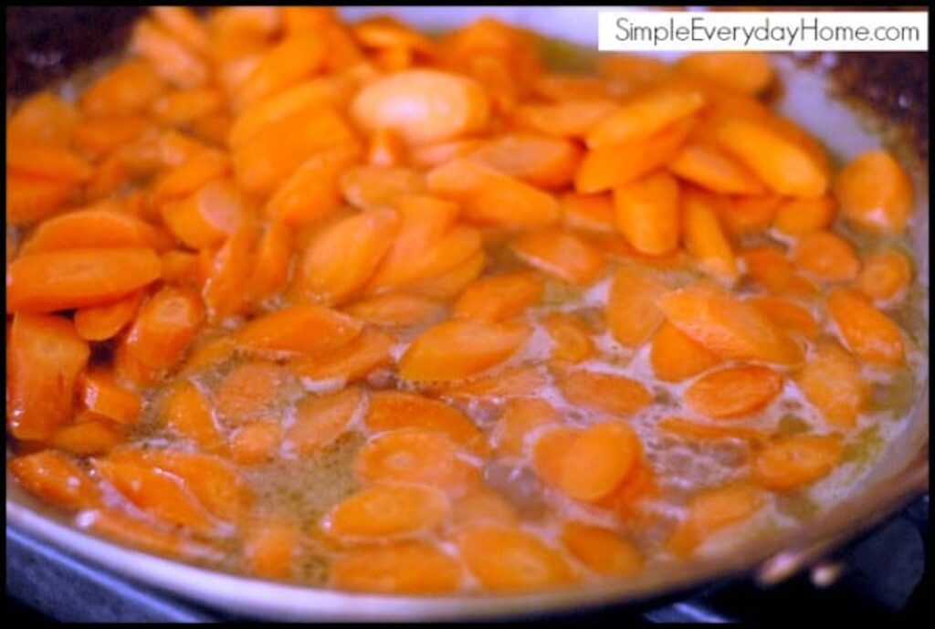 Carrots cooking in pan with glaze bubbling