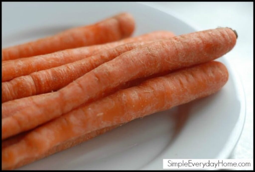 Whole raw unpeeled carrots on a plate