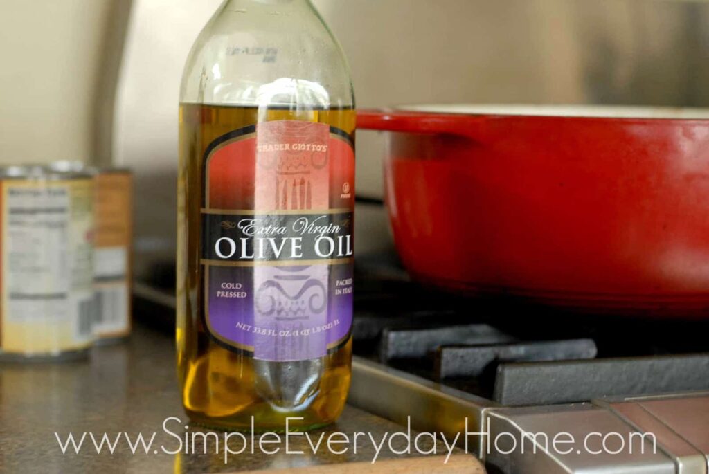 Bottle of olive oil setting beside stove